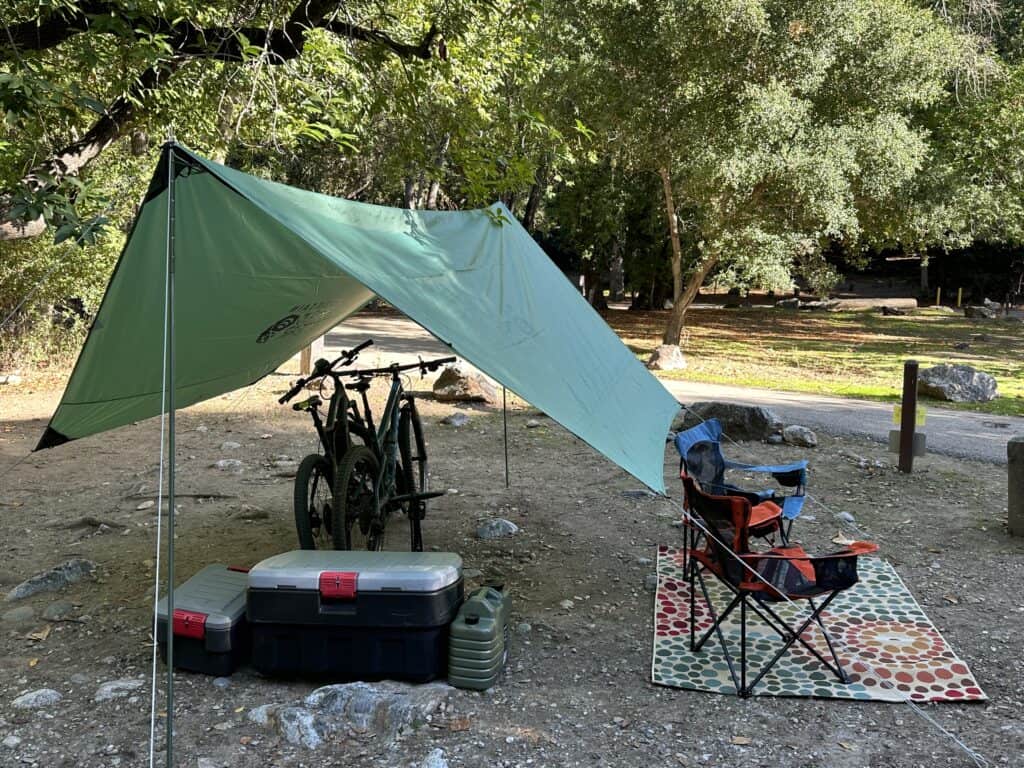 green canopy tent over camping gear and bikes