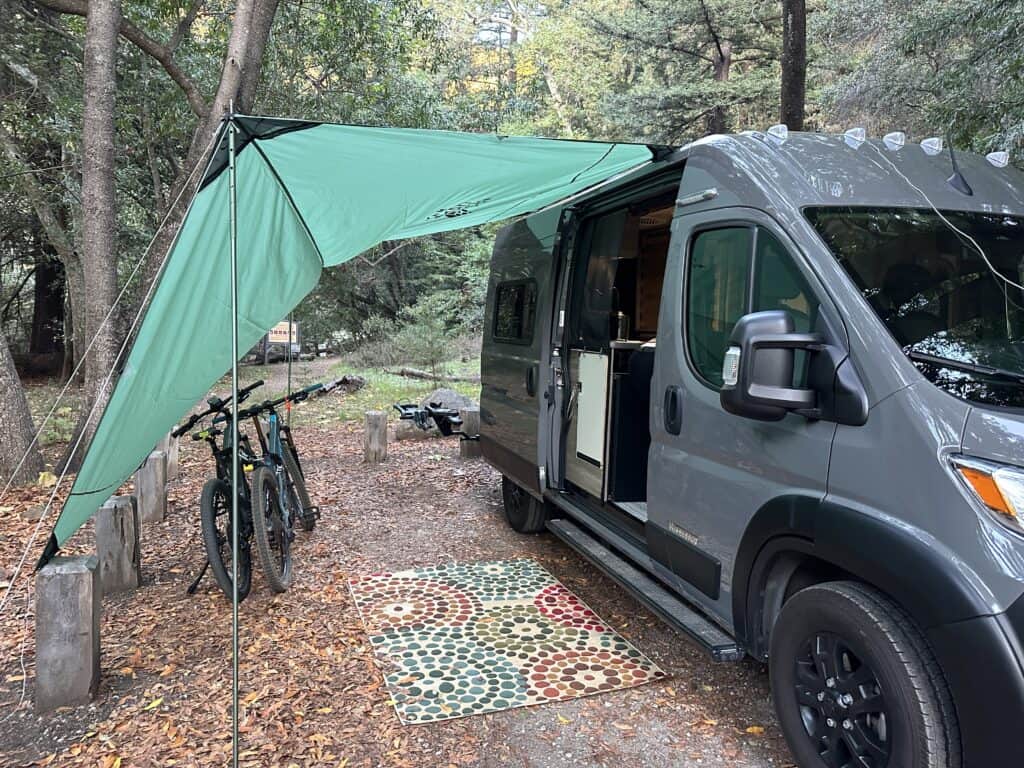 green canopy attached to the side of a camper van
