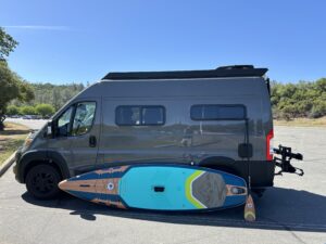 side view of our van with a paddle board leaning against it
