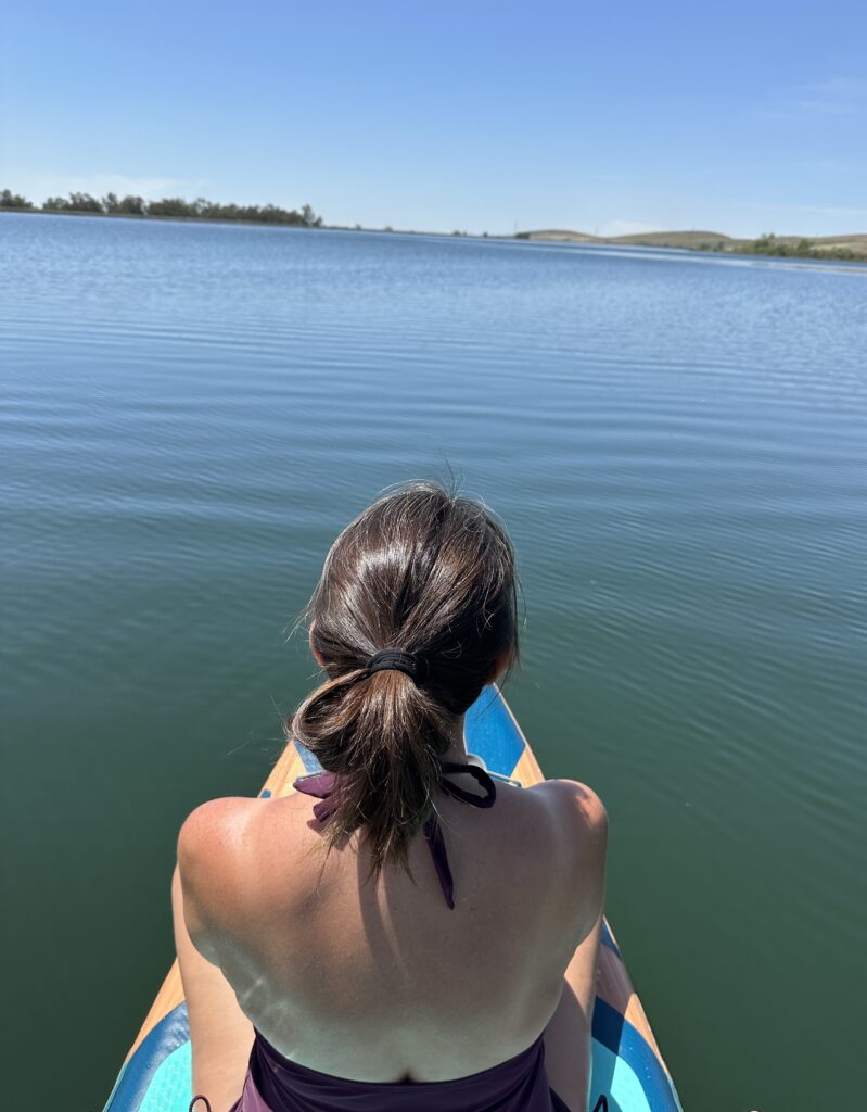 marla sitting on the front of the paddle board